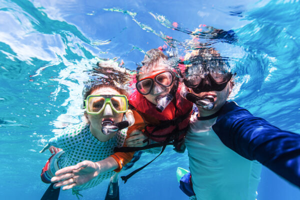 Underwater portrait of family snorkeling together at clear tropical ocean; Shutterstock ID 266004011; Purchase Order: -