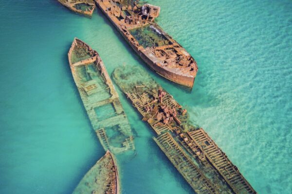The Tangalooma Wrecks used to be 15 steam driven barges which were deliberately sunk in 1963 along the Moreton Island coastline to form a breakwall so that small boats can anchor in shelter.; Shutterstock ID 1403023370; purchase_order: -; job: -; client: -; other: -